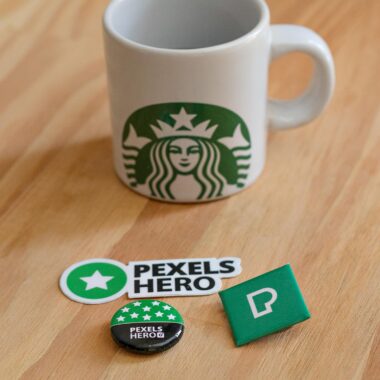 A Starbucks Cup near the Pexels Pin and Sticker